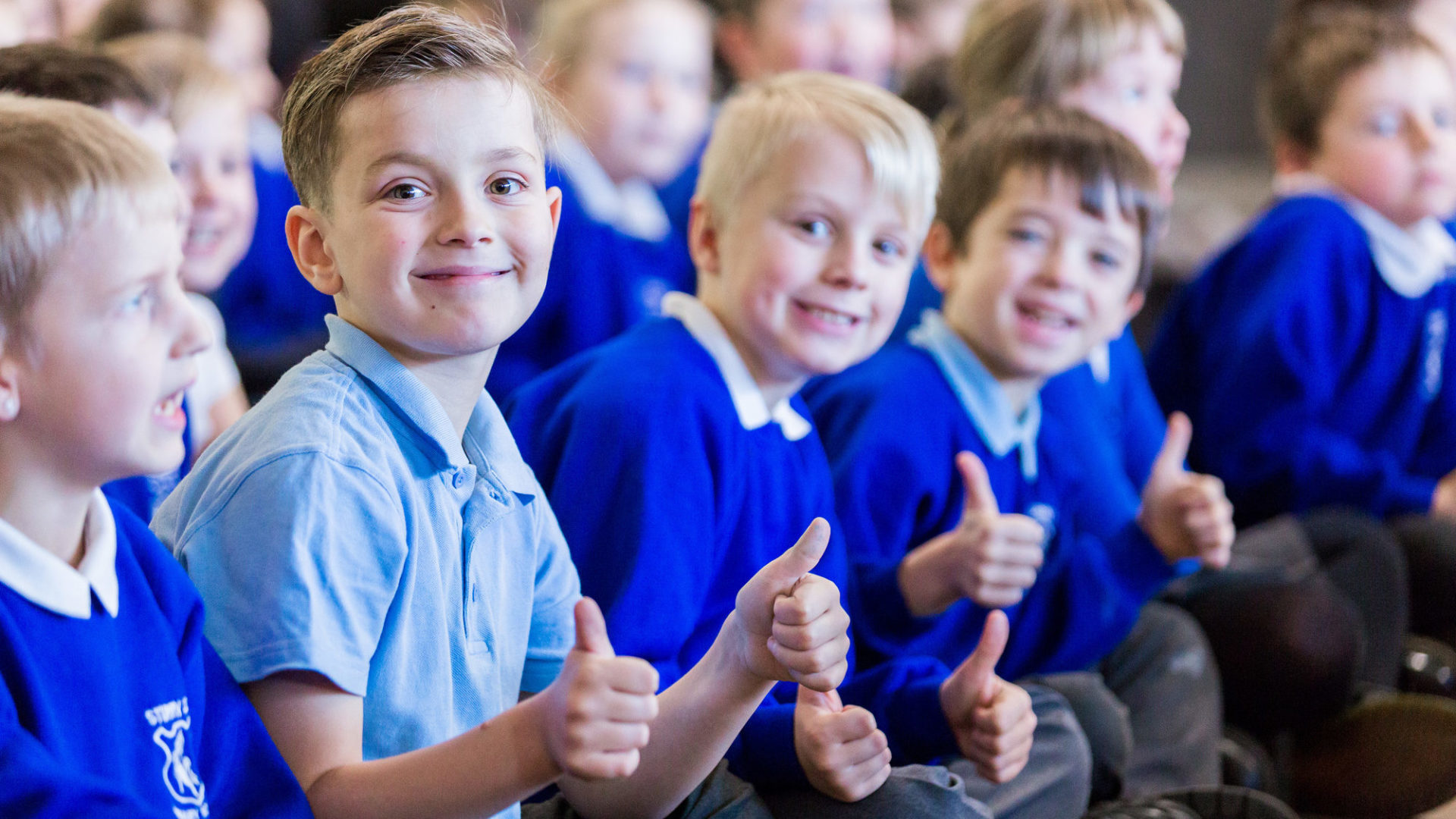 children in primary school enjoying collective worship assembly time.